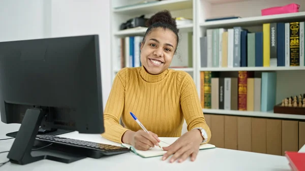 Νεαρή Αφρο Αμερικανίδα Φοιτήτρια Κρατάει Σημειώσεις Στη Βιβλιοθήκη — Φωτογραφία Αρχείου