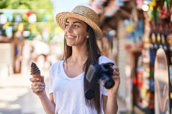 Young Hispanic Woman Tourist Eating Ice Cream Holding Reflex Camera — Stockfoto