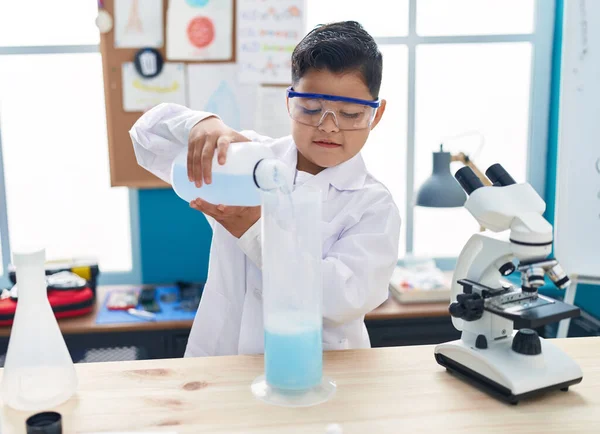 stock image Adorable hispanic boy student smiling confident pouring liquid on test tube at laboratory classroom