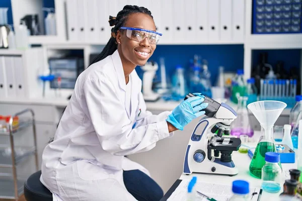 African American Woman Scientist Smiling Confident Using Microscope Laboratory — Stock fotografie