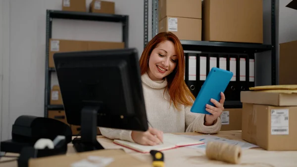 在办公室使用触摸板的红头发年轻女性电子商务工作者 — 图库照片