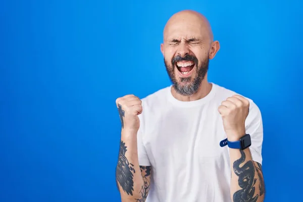 Spanyol Férfi Tetoválásokkal Áll Kék Háttér Felett Ünneplő Meglepett Csodálkozott — Stock Fotó