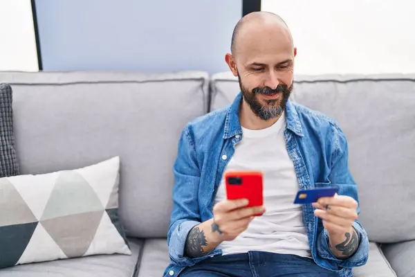 Young Bald Man Using Smartphone Credit Card Sitting Sofa Home — Fotografia de Stock
