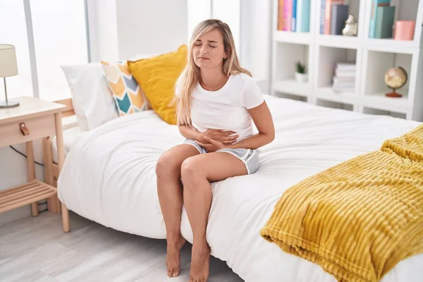 Young Blonde Woman Suffering Menstrual Pain Sitting Bed Bedroom — ストック写真