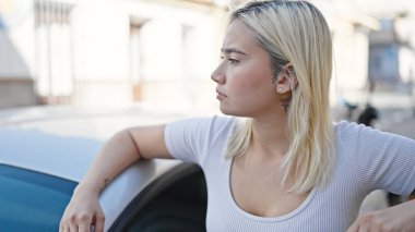 Genç, güzel, İspanyol bir kadın caddede arabanın kapısına dayanmış.