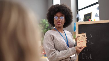 African american woman preschool teacher having vocabulary lesson at kindergarten