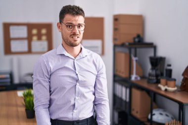 Ofisteki genç, şaşkın, şüpheci ve iğneleyici bakışlı ağzı açık, şaşırmış İspanyol bir adam. 