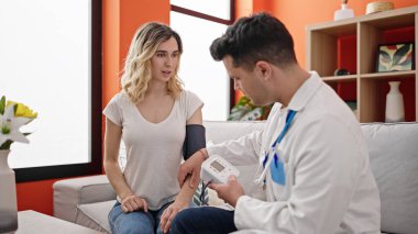 Erkek ve kadın doktor ve hasta nabız ölçümleri evde gerilim ölçer.