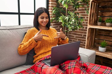 Evde sağır işaret dili kullanan genç Latin bir kadın var.