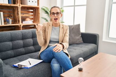 Muayenehanede çalışan genç bir kadın elleri yana doğru işaret ederek şaşırdı, ağzı açık hayret içinde kaldı.. 