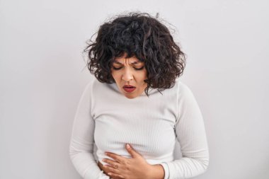 Kıvırcık saçlı İspanyol kadın midesi üstünde el üstünde duruyor çünkü hazımsızlık, acı verici bir hastalık kendini iyi hissetmiyor. Ağrı kavramı. 