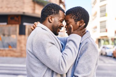 Man and woman couple hugging each other standing at street