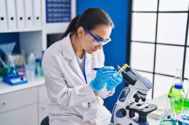 Laboratuvarda test tüpüne yazı yazan genç İspanyol bilim kadını.