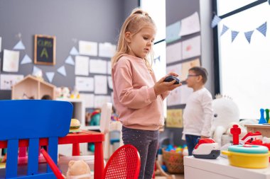 Erkek ve kız öğrenciler anaokulunda oyuncaklarla oynuyorlar.