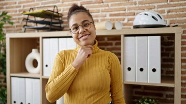 Young african american woman smiling confident wearing glasses at office