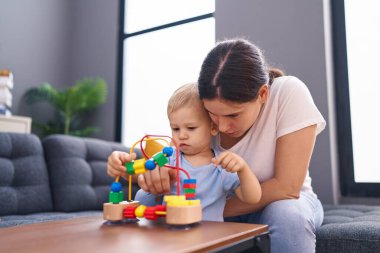 Mother and son sitting on sofa playing at home