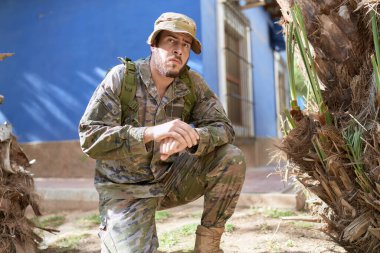 Asker üniforması giyen İspanyol genç adam parkı gözetliyor.