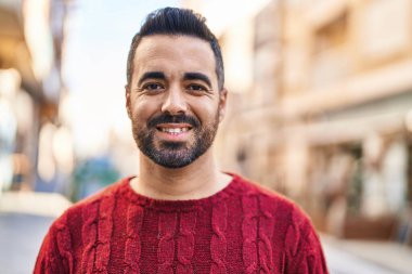 Sokakta kendinden emin gülümseyen İspanyol genç adam.