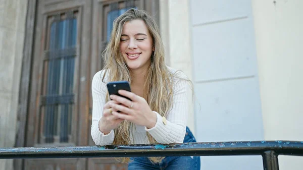 Jonge Blonde Vrouw Glimlachen Zelfverzekerd Met Behulp Van Smartphone Straat — Stockfoto