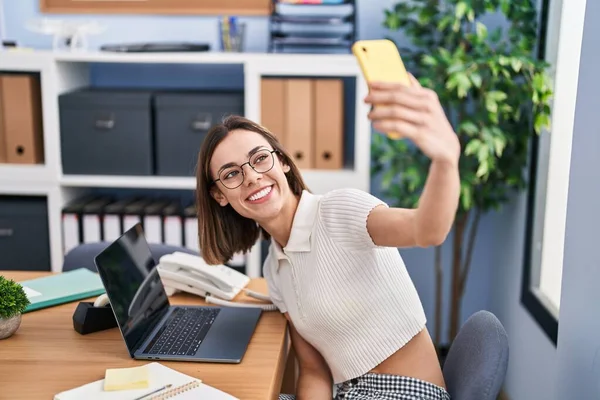 若い美しいヒスパニック女性ビジネスワーカー作る自撮りによるスマートフォンでオフィス — ストック写真