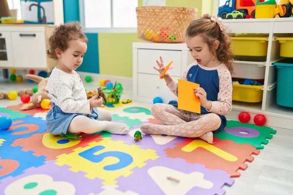 Entzückende Mädchen Schneiden Papier Und Spielen Mit Dinosaurier Spielzeug Kindergarten — Stockfoto