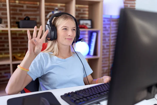 Mladá Běloška Hraje Videohry Sluchátkách Ukazující Ukazující Prsty Číslo Čtyři — Stock fotografie