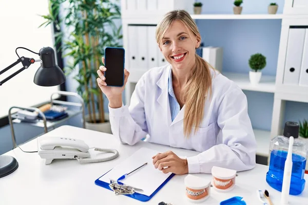 Mulher Dentista Bonita Mostrando Tela Smartphone Olhando Positivo Feliz Sorrindo — Fotografia de Stock