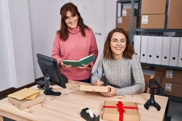 Two Women Ecommerce Business Workers Writing Package Reading Book Office — Φωτογραφία Αρχείου