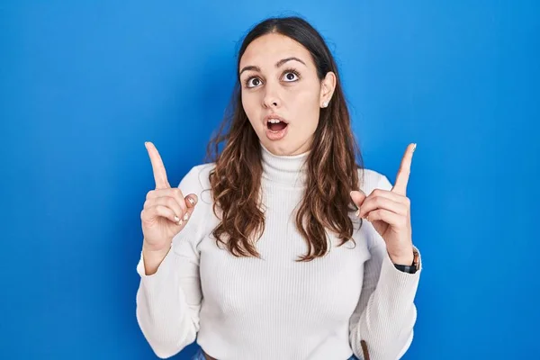 Young Hispanic Woman Standing Blue Background Amazed Surprised Looking Pointing — Stock Photo, Image