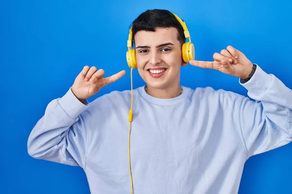 Non Binární Člověk Poslouchá Hudbu Pomocí Sluchátek Veselým Úsměvem Ukazující — Stock fotografie