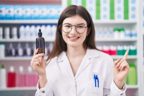 Joven Mujer Caucásica Trabajando Farmacia Sosteniendo Suero Sonriendo Feliz Señalando —  Fotos de Stock