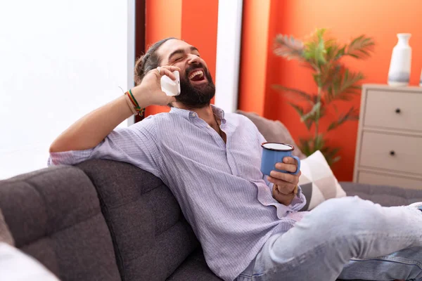 Νεαρός Ισπανόφωνος Μιλάει Στο Smartphone Πίνοντας Καφέ Στο Σπίτι — Φωτογραφία Αρχείου
