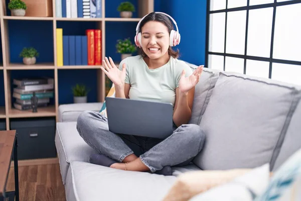 Mujer Joven Hispana Usando Laptop Casa Usando Auriculares Celebrando Locos — Foto de Stock