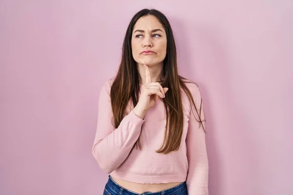 Young Brunette Woman Standing Pink Background Thinking Concentrated Doubt Finger — Photo