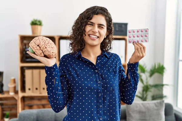 Young Brunette Woman Holding Brain Pills Mental Health Concept Winking — Stock Photo, Image