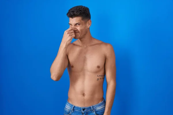 Ung Latinamerikansk Man Står Skjorta Över Blå Bakgrund Luktar Något — Stockfoto