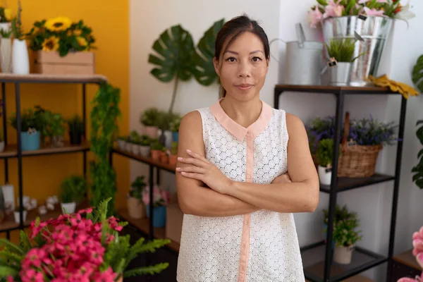 年轻的亚洲女人花匠微笑着 自信地站在花店里 双手交叉地做着手势 — 图库照片