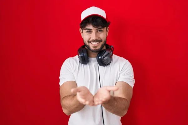 Hispanischer Mann Mit Bart Gamermütze Und Kopfhörer Lächelnd Mit Handflächen — Stockfoto