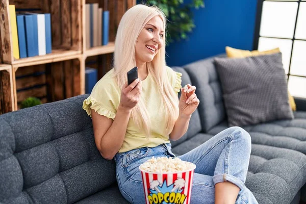 Young Blonde Woman Watching Movie Sitting Sofa Home — Foto Stock