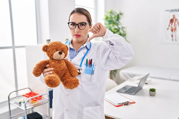 Young Hispanic Pediatrician Woman Holding Teddy Bear Clinic Angry Face — Stock Photo, Image