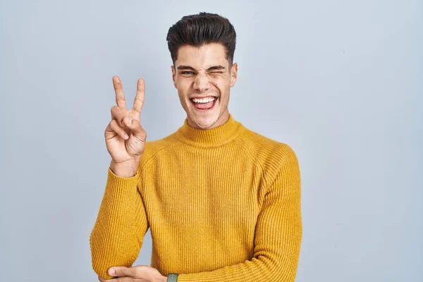 Homem Hispânico Jovem Sobre Fundo Azul Sorrindo Com Rosto Feliz — Fotografia de Stock