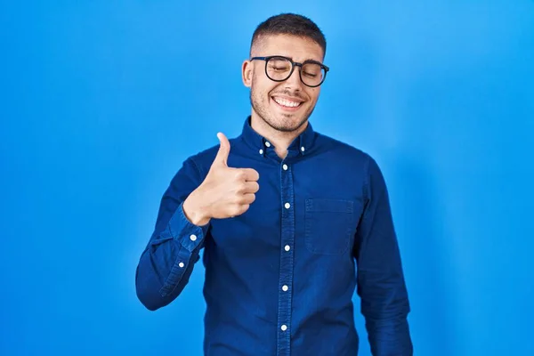 Mavi Arka Planda Gözlük Takan Spanyol Genç Adam Mutlu Bir — Stok fotoğraf