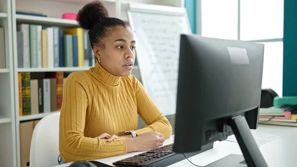 在图书馆使用计算机学习的年轻非洲裔美国女学生 — 图库照片