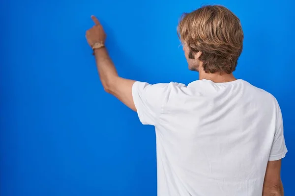 Middelbare Leeftijd Man Staande Blauwe Achtergrond Poseren Achteruit Wijzen Vooruit — Stockfoto