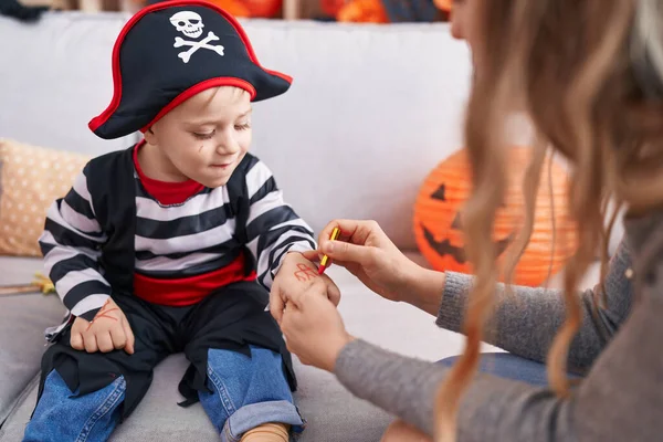 Adorable caucasian boy wearing pirate costume having draw on hand at home