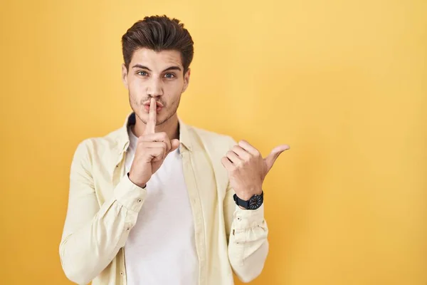 Young Hispanic Man Standing Yellow Background Asking Quiet Finger Lips — Stock fotografie