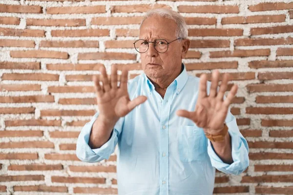 Senior Man Met Grijs Haar Staat Bakstenen Muur Weg Bewegen — Stockfoto