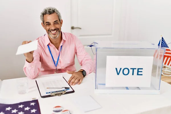 stock image Middle age grey-haired man electoral table president holding vote paper at electoral college