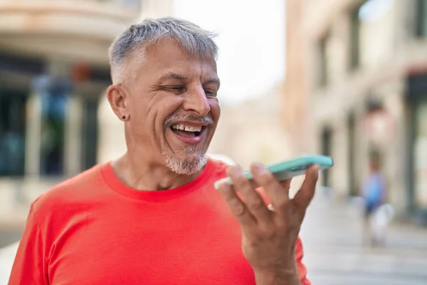 中年白发男人在街上用智能手机自信地微笑交谈 — 图库照片