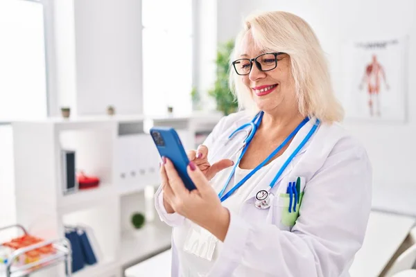 Blonde Frau Mittleren Alters Arztuniform Mit Smartphone Klinik — Stockfoto